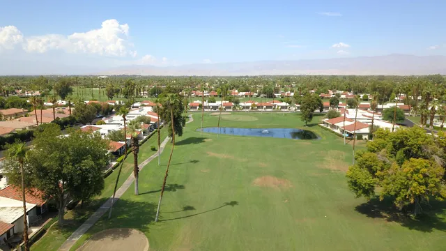 an aerial view of residential houses with outdoor space and trees