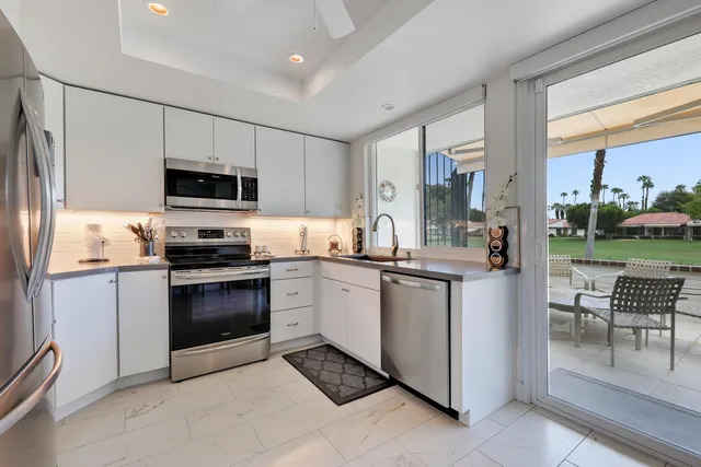 a kitchen with stainless steel appliances granite countertop a refrigerator and a stove top oven