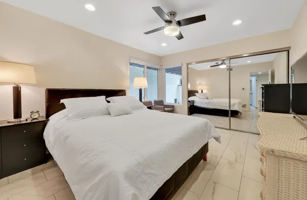 a large bedroom with a large bed and a view of living room