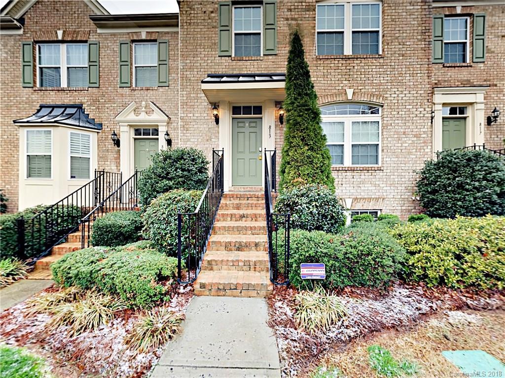 a front view of a house with a yard and potted plants