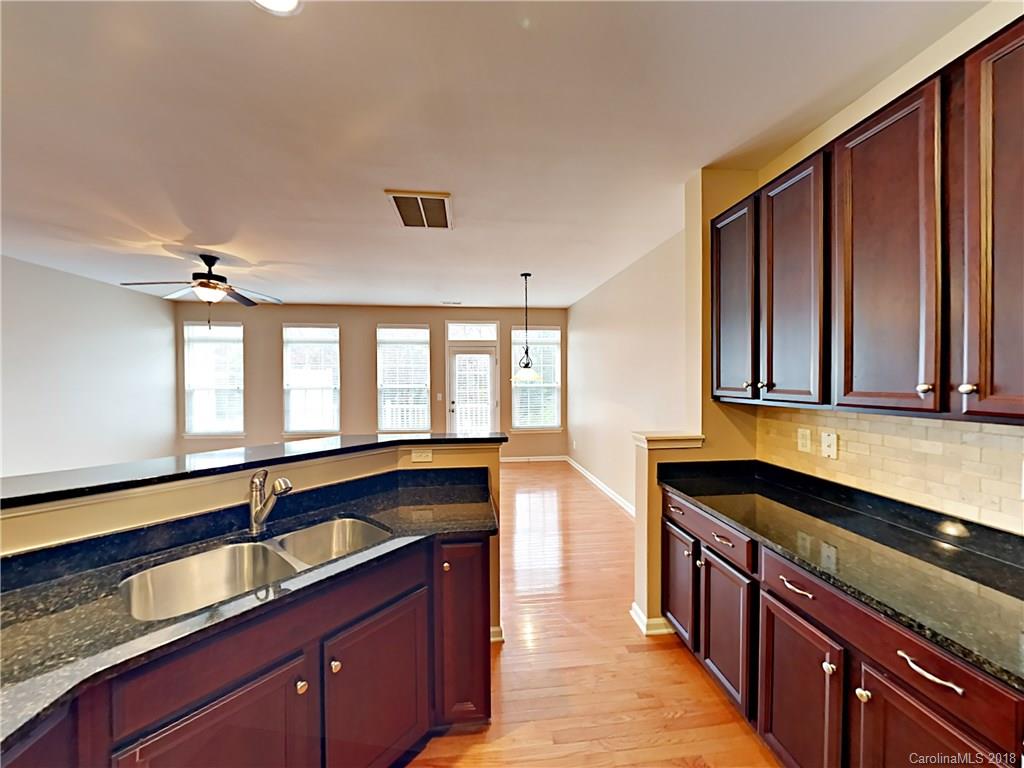 813 Kimbrough Court Davidson, NC 28036 - Photo 10 of 22 a kitchen with granite countertop a sink and a wooden cabinets