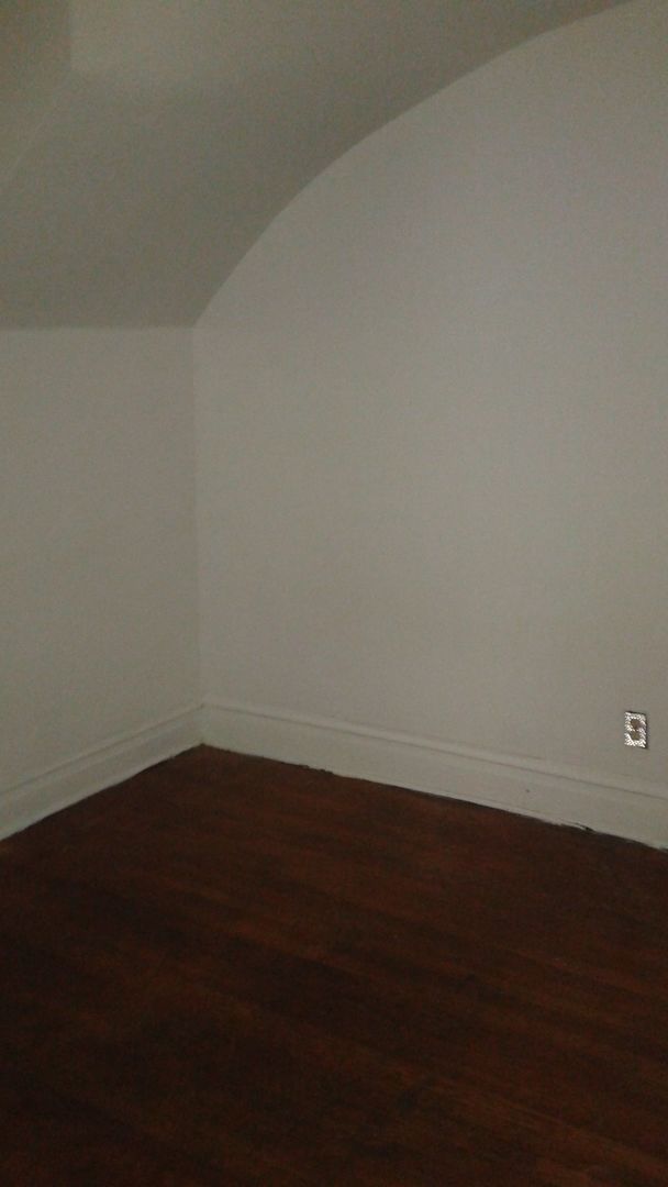 2421 North Harding Avenue, Unit 1 Chicago, IL 60647 - Photo 13 of 14 a view of an empty room with wooden floor and a window