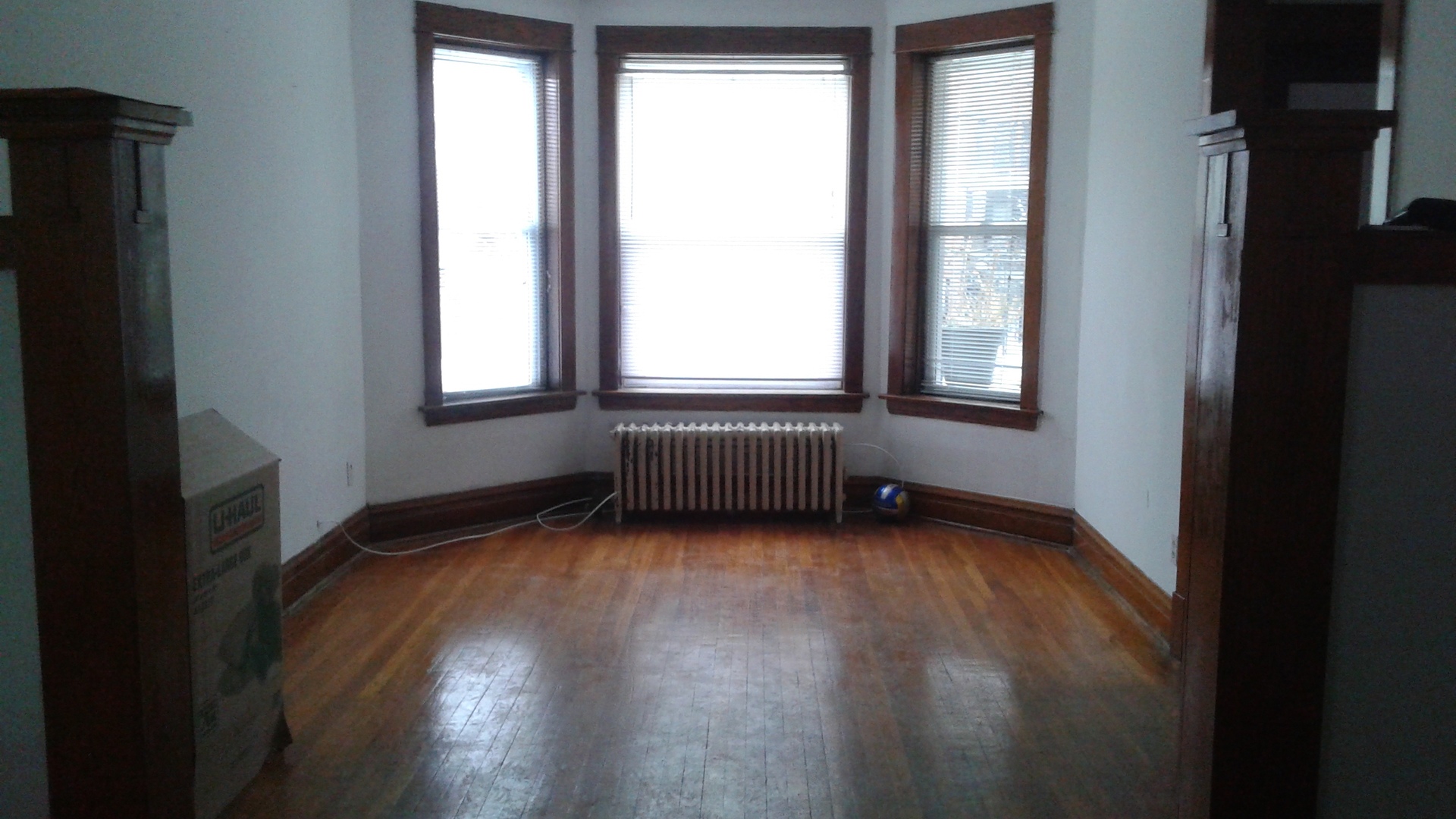 2421 North Harding Avenue, Unit 1 Chicago, IL 60647 - Photo 5 of 14 an empty room with wooden floor and windows