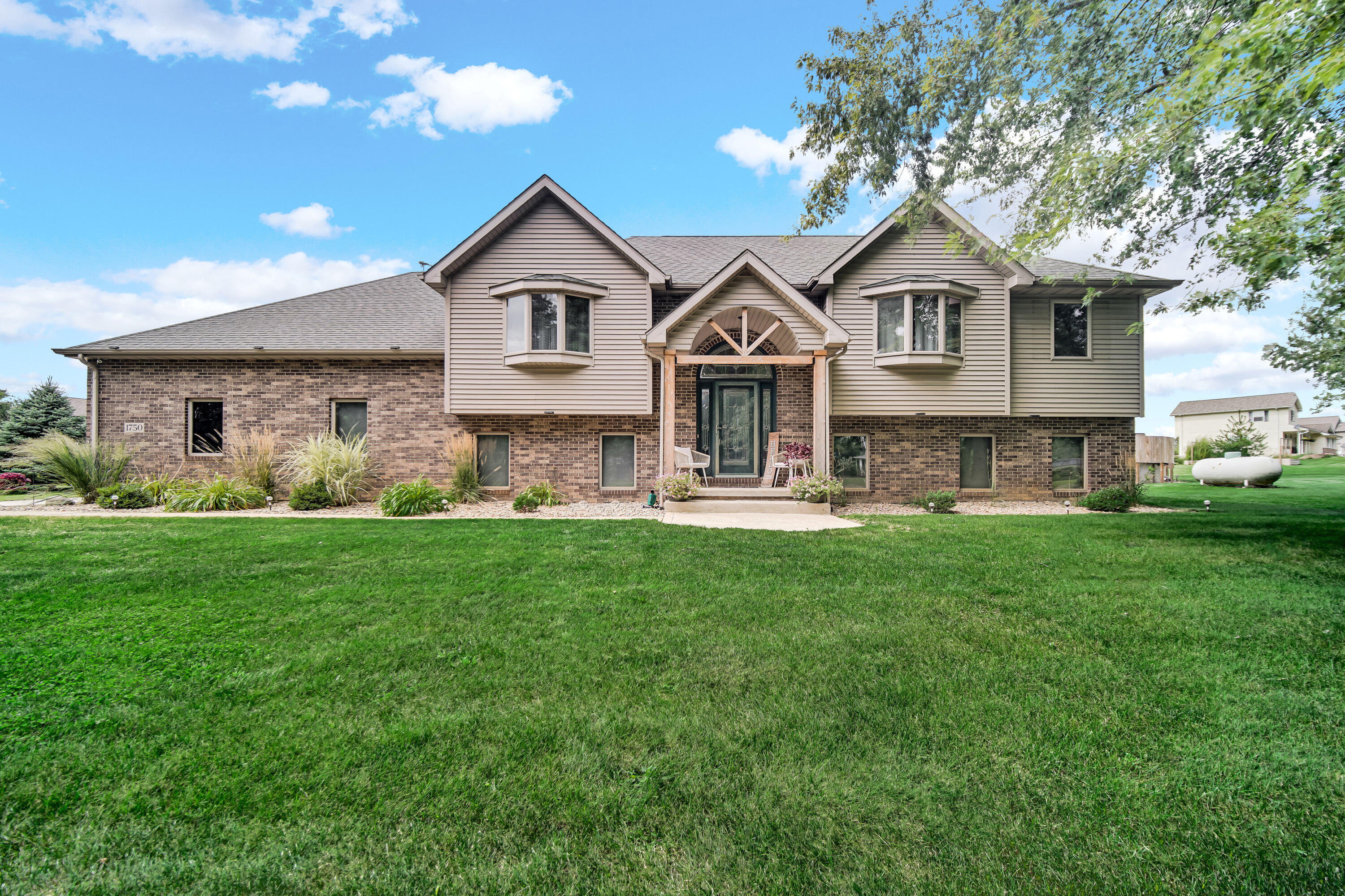 1750 West 174th Place Lowell, IN 46356 - Photo 1 of 23 a front view of a house with a yard and green space