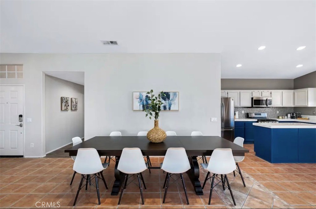 83250 Beverly Court Indio, CA 92201 - Photo 17 of 29 a dining room with stainless steel appliances kitchen island granite countertop a dining table chairs and a refrigerator