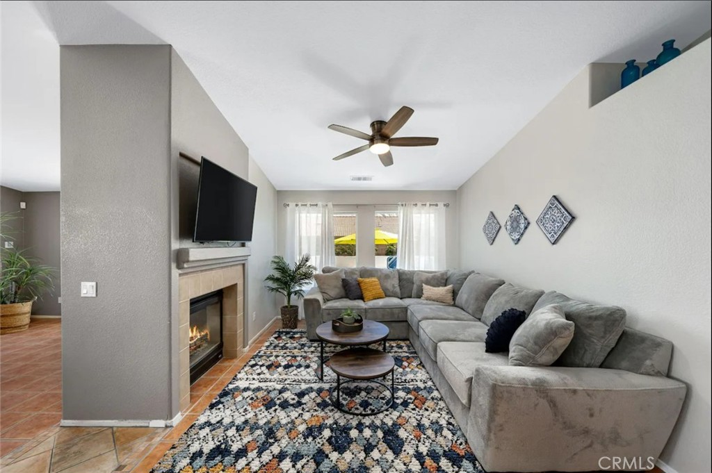 83250 Beverly Court Indio, CA 92201 - Photo 18 of 29 a living room with furniture a fireplace and a flat screen tv