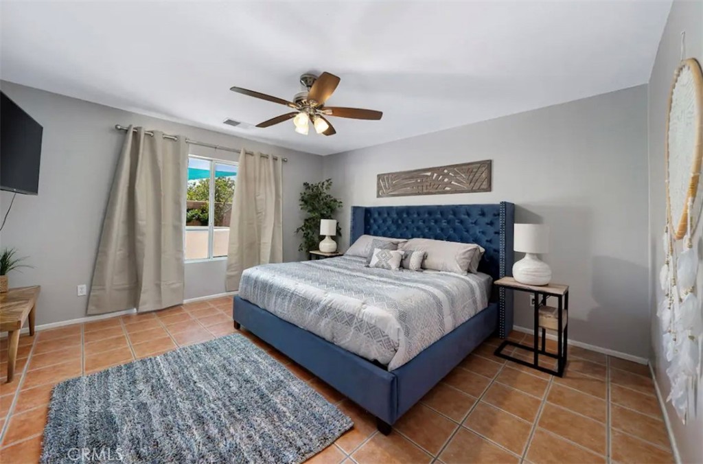 83250 Beverly Court Indio, CA 92201 - Photo 20 of 29 a bedroom with a large bed chandelier and a window