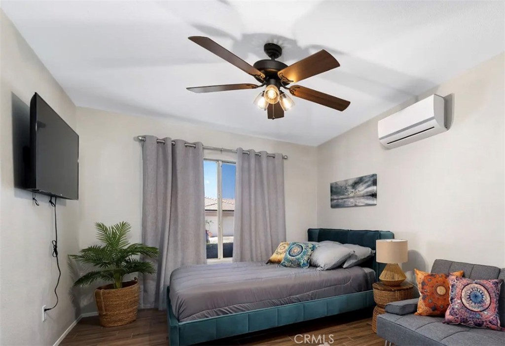 83250 Beverly Court Indio, CA 92201 - Photo 23 of 29 a bedroom with a bed a couch and a potted plant
