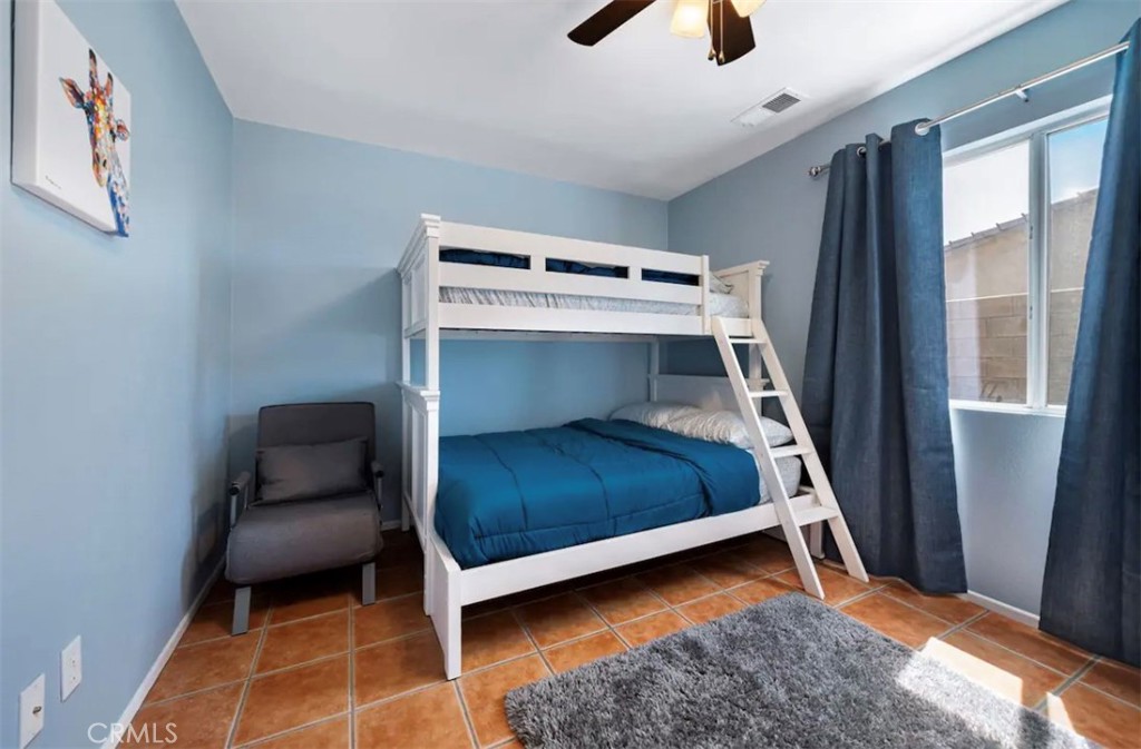 83250 Beverly Court Indio, CA 92201 - Photo 27 of 29 a bedroom with a bed and a chair