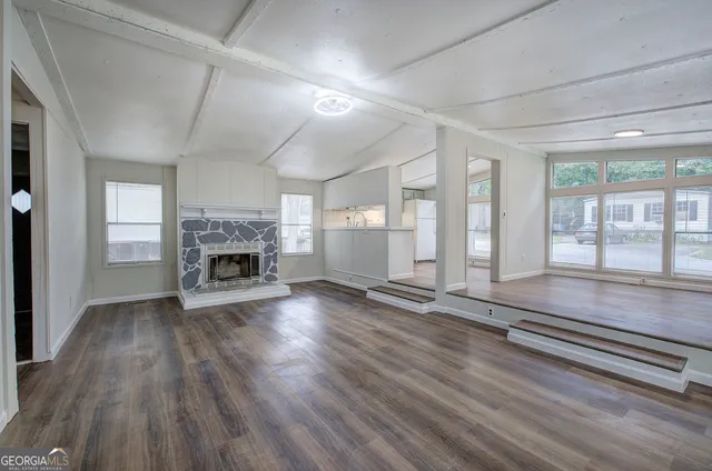 an empty room with wooden floor and fireplace