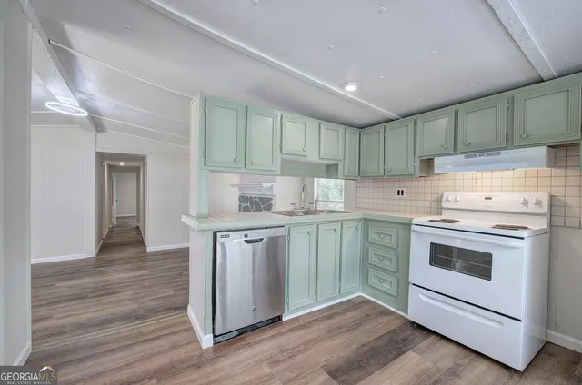 a kitchen with a stove cabinets and wooden floor