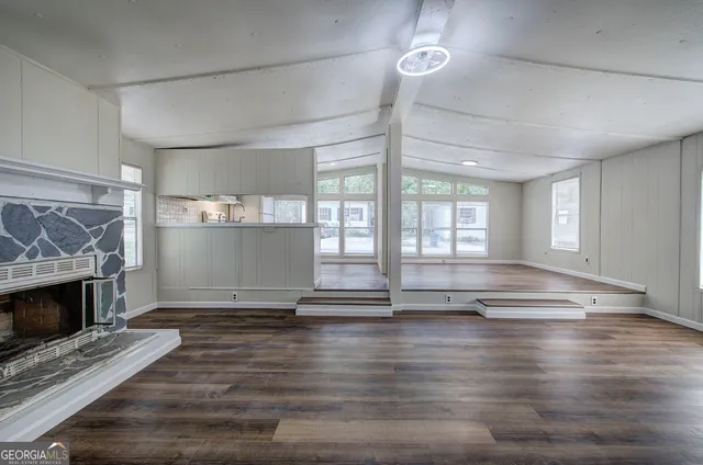 a view of empty room with wooden floor and fireplace