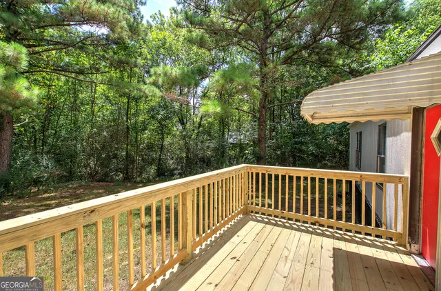 a balcony with wooden floor and yard in the back