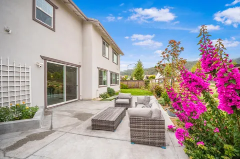 a view of a patio with couches table and chairs and potted plants