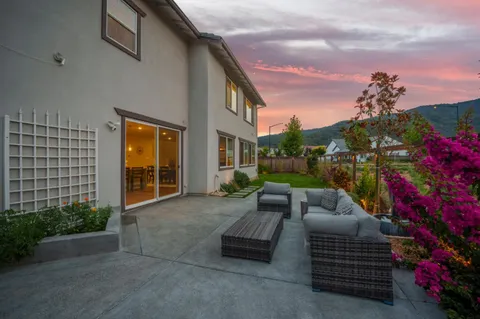 a view of a patio with couches table and chairs and potted plants