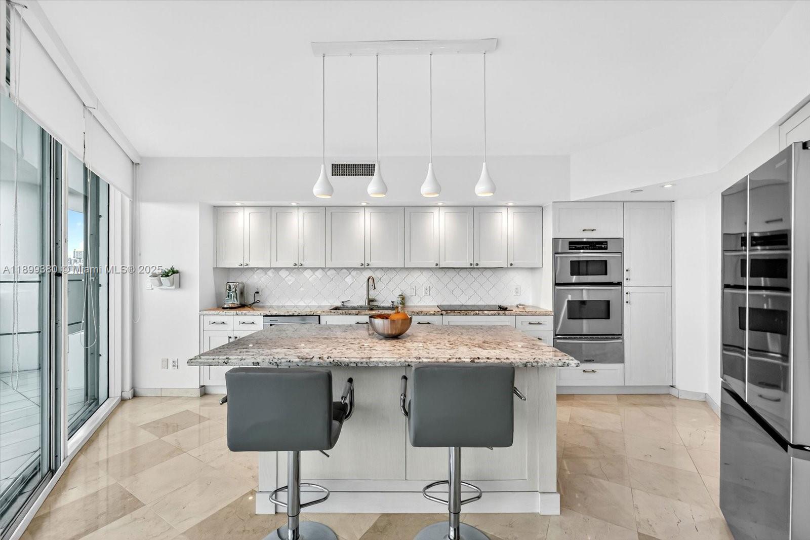 2127 Brickell Avenue, Unit 2005 Miami, FL 33129 - Photo 15 of 53 a kitchen with stainless steel appliances granite countertop a stove a sink and a refrigerator