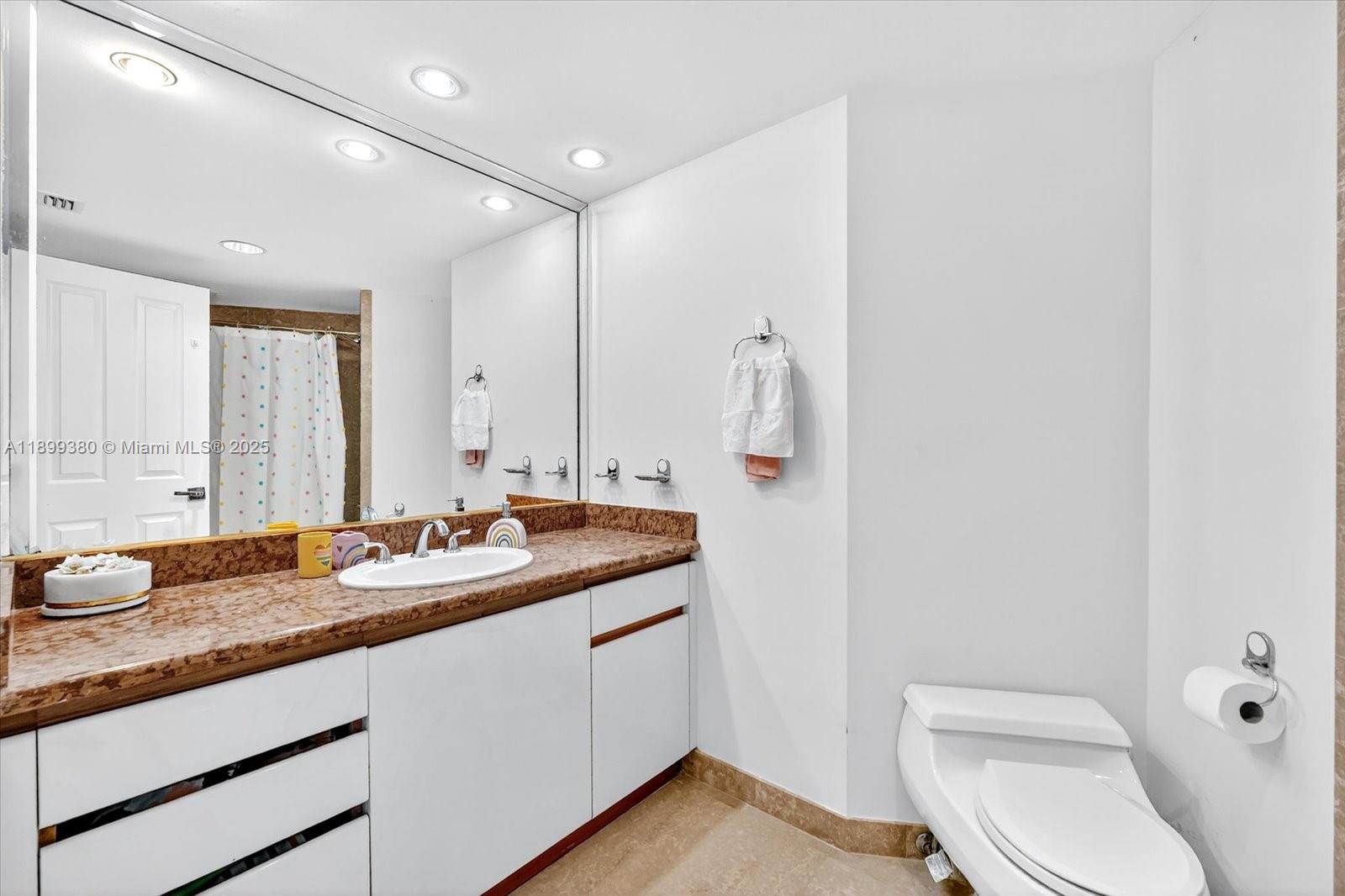 2127 Brickell Avenue, Unit 2005 Miami, FL 33129 - Photo 23 of 53 a bathroom with a granite countertop sink a toilet and a mirror