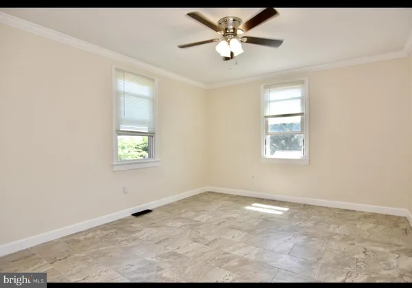 an empty room with a window and a ceiling fan