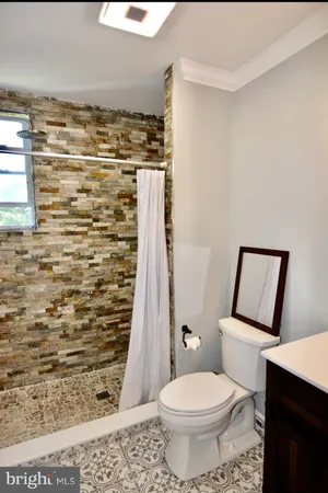 a bathroom with a toilet and a shower
