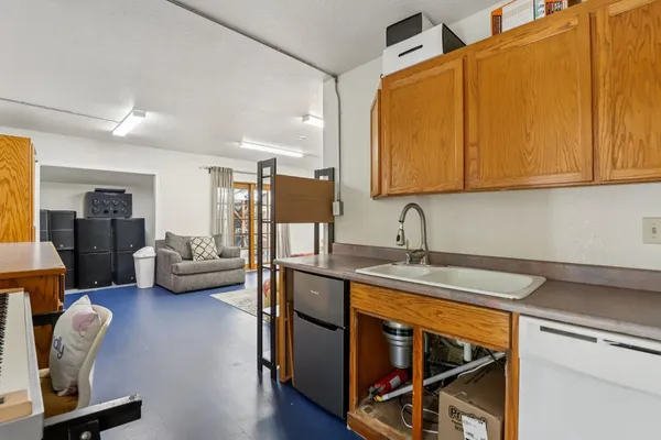 a view of kitchen with stainless steel appliances granite countertop a sink and wooden cabinets