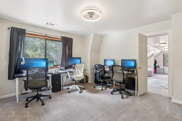 a view of a workspace with furniture and a window