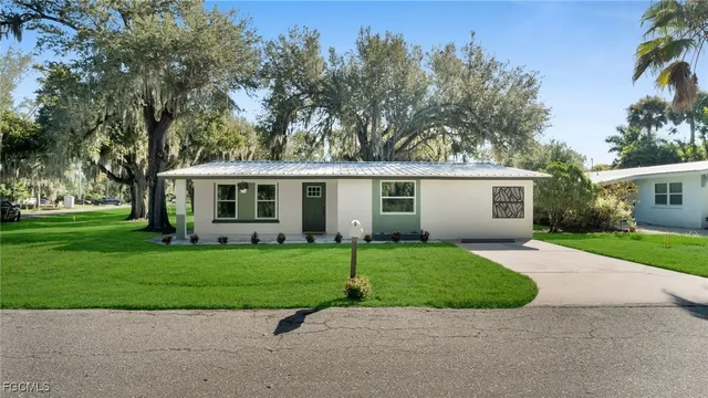 front view of a house with a yard and a garden