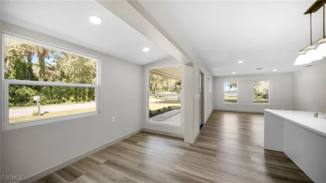 a view of a hallway with wooden floor and windows