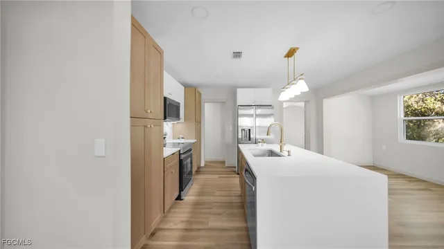 a dining hall with stainless steel appliances a chandelier