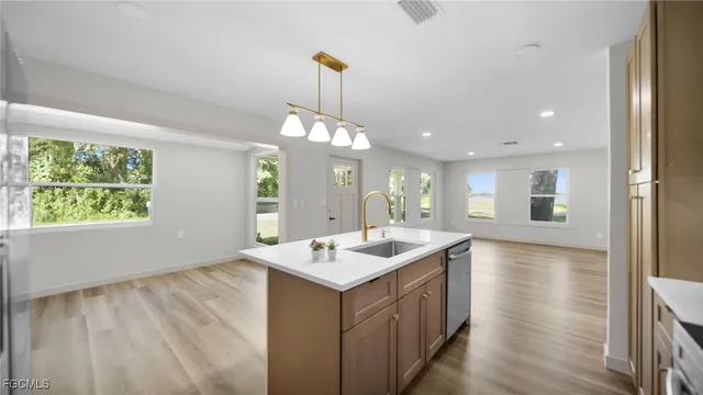 a kitchen with a sink stove and wooden floor