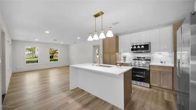 a kitchen with kitchen island a sink stainless steel appliances and cabinets