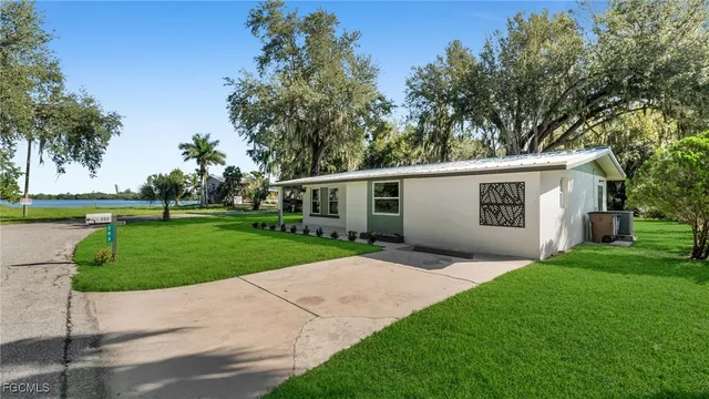 a view of a house with a yard and tree s