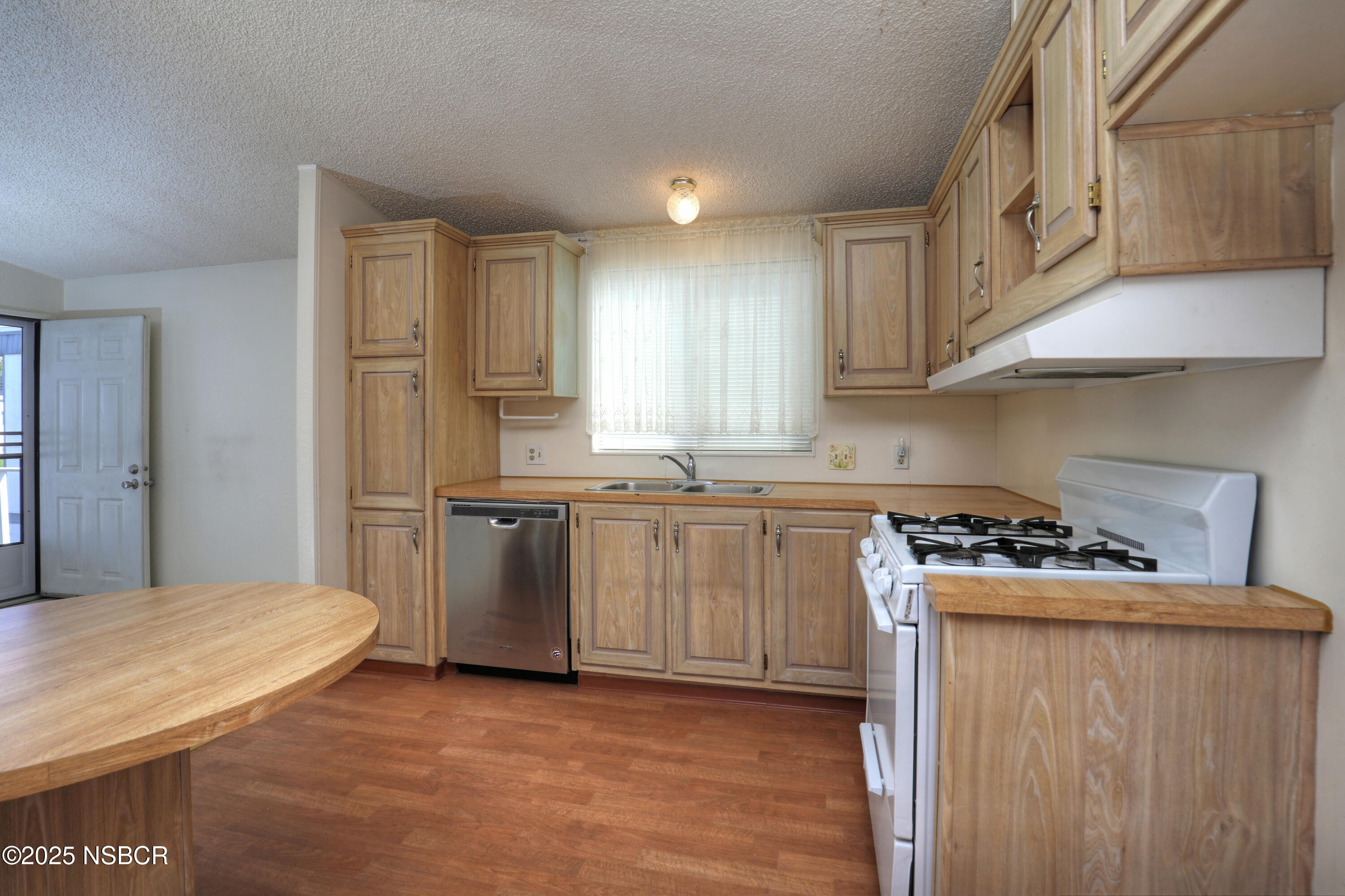 80 Zaca Street, Unit 4 Buellton, CA 93427 - Photo 7 of 25 a kitchen with a stove a sink and a refrigerator
