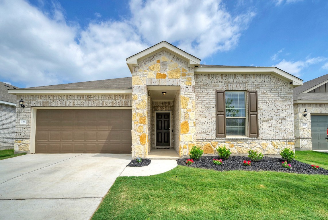 a front view of a house with a yard and garage