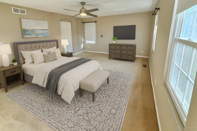 a bedroom with a bed flat screen tv and a couch