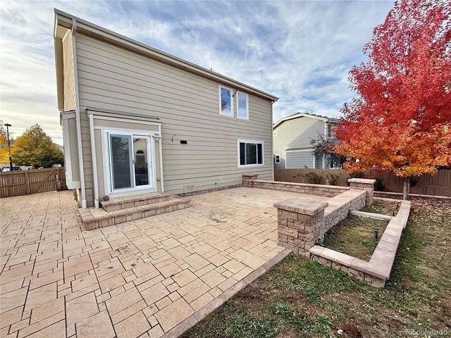 a view of a house with backyard and trees