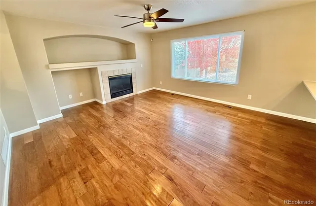 an empty room with windows and fireplace