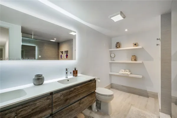 a bathroom with a sink a toilet and a mirror