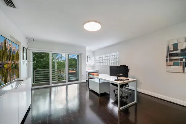 a view of a workspace with furniture and a window