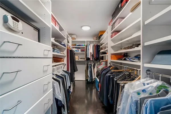 a view of walk in closet with clothes and shoes