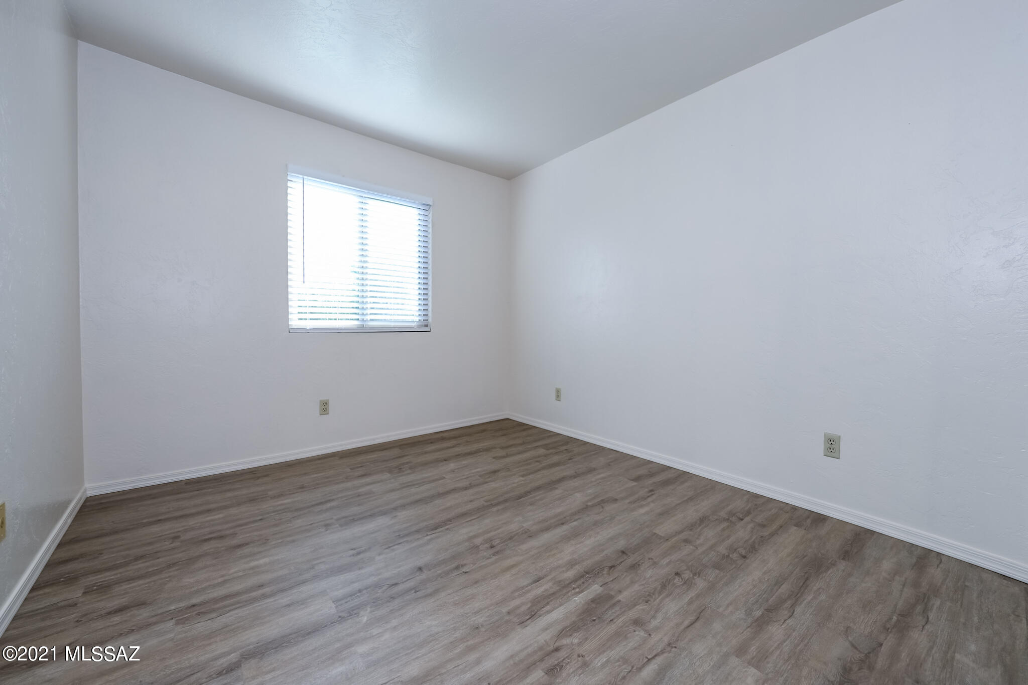 312 East 24th Street, Unit 4 Tucson, AZ 85713 - Photo 11 of 17 an empty room with wooden floor and window