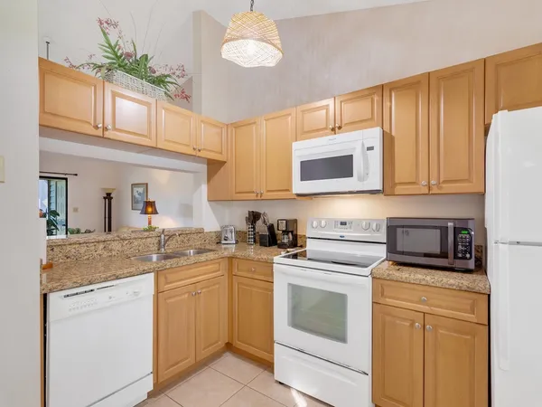 a kitchen with stainless steel appliances granite countertop white cabinets a stove a sink and dishwasher