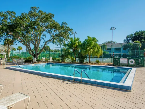 a view of swimming pool with a bench and trees
