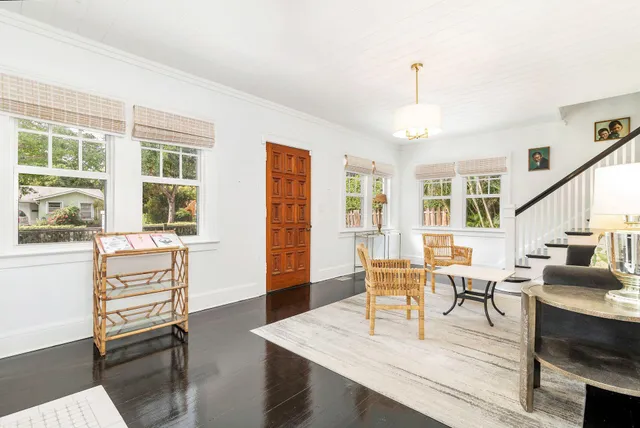 a living room with furniture a dining table and a large window