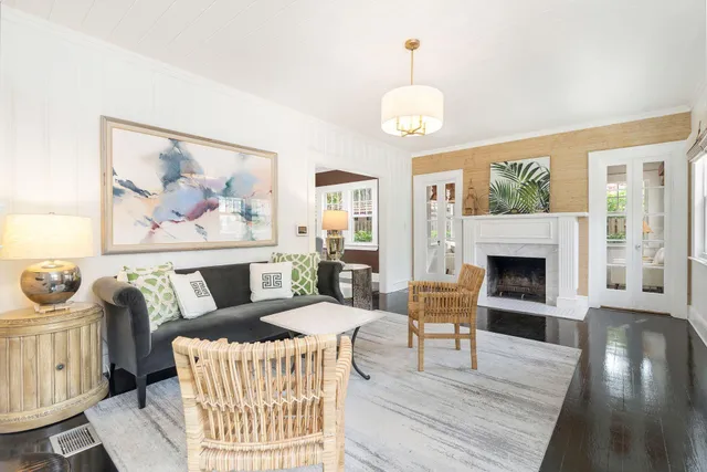 a living room with furniture a fireplace and a large window