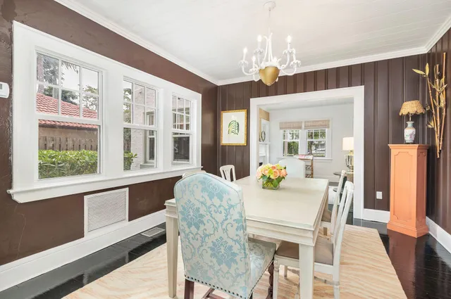 a dining room with furniture a chandelier and wooden floor