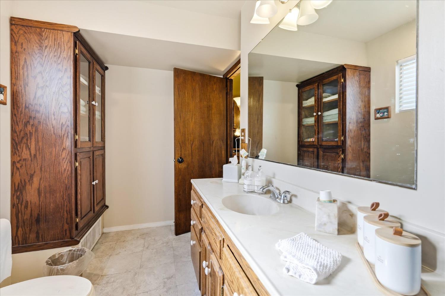 31325 Delaware Road Coarsegold, CA 93614 - Photo 29 of 39 a bathroom with a granite countertop sink and a mirror