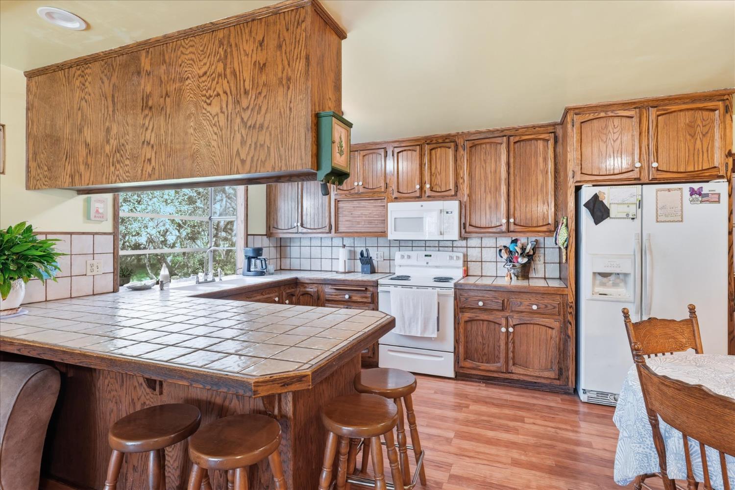 31325 Delaware Road Coarsegold, CA 93614 - Photo 3 of 39 a kitchen with granite countertop a wooden table chairs cabinets and stainless steel appliances