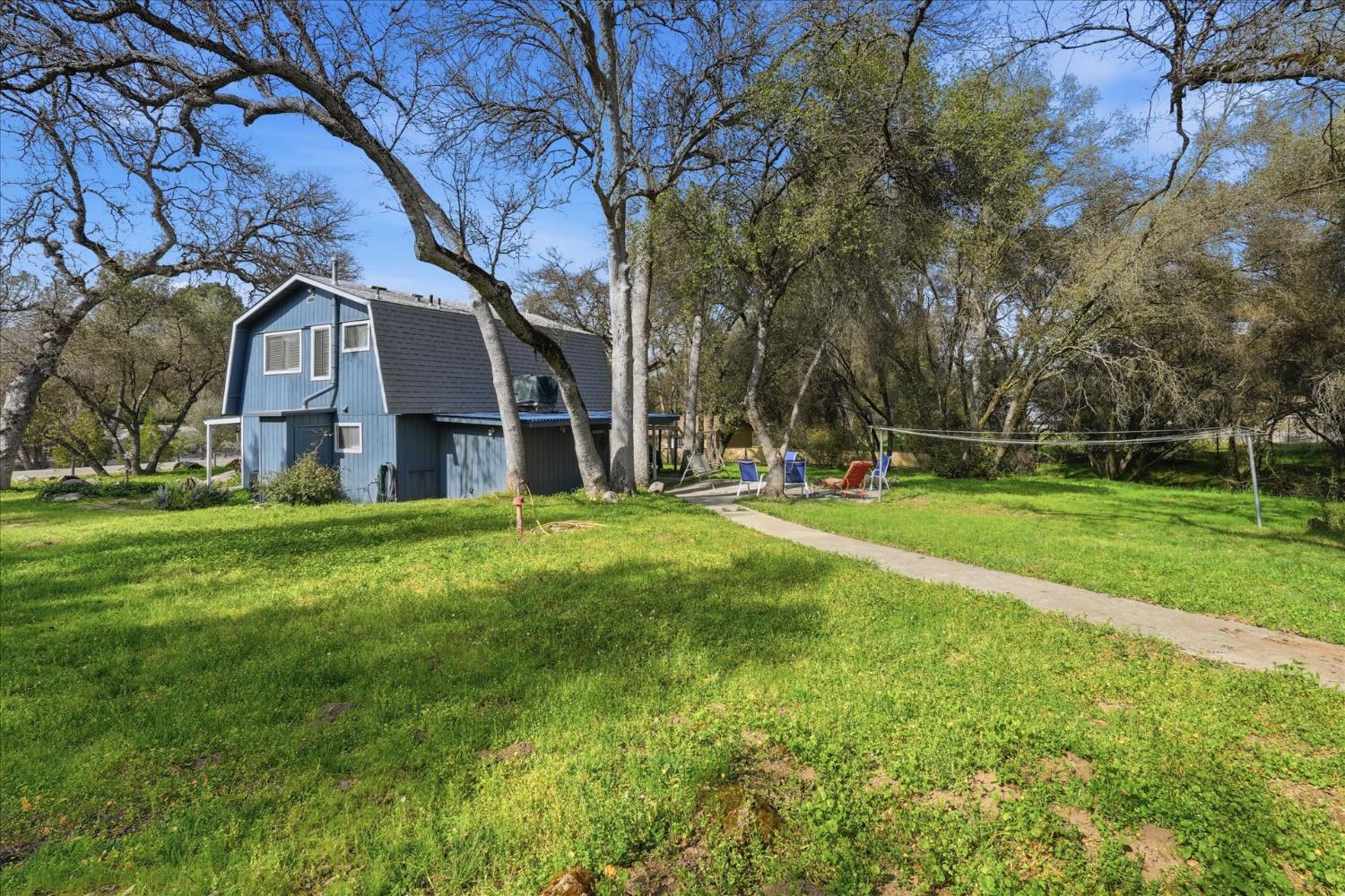 31325 Delaware Road Coarsegold, CA 93614 - Photo 8 of 39 a view of a house with a big yard and large trees