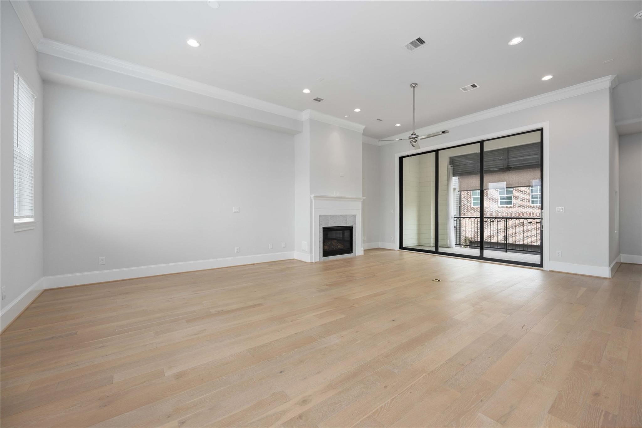 10919 Grove Tree Lane Houston, TX 77043 - Photo 13 of 43 a view of an empty room with a fireplace and a window