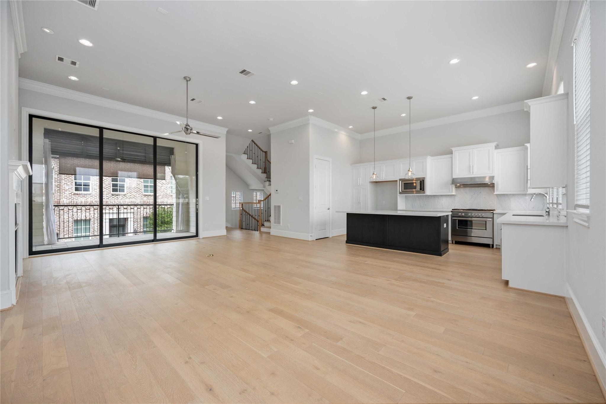 10919 Grove Tree Lane Houston, TX 77043 - Photo 15 of 43 a large white kitchen with large windows and cabinets